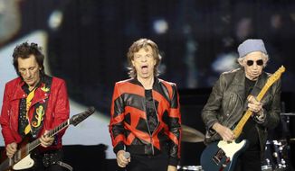 Ronnie Wood, left, Mick Jagger, center, and Keith Richards, of the Rolling Stones play on stage at the Anfield stadium in Liverpool, England, during a concert as part of their &amp;quot;Sixty&amp;quot; European tour, Thursday, June 9, 2022. The Rolling Stones canceled their concert in Amsterdam Monday just hours before it was due to start after lead singer Mick Jagger tested positive for COVID-19.The band announced the cancelation in a statement, saying the 78-year-old Jagger tested positive “after experiencing symptoms of COVID upon arrival at the stadium” on the outskirts of Amsterdam. (AP Photo/Scott Heppell, File)