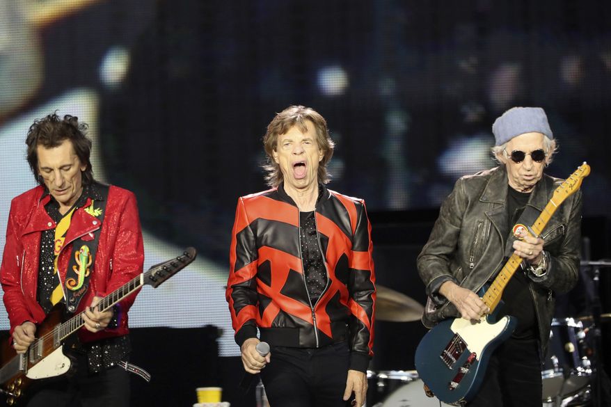 Ronnie Wood, left, Mick Jagger, center, and Keith Richards, of the Rolling Stones play on stage at the Anfield stadium in Liverpool, England, during a concert as part of their &amp;quot;Sixty&amp;quot; European tour, Thursday, June 9, 2022. The Rolling Stones canceled their concert in Amsterdam Monday just hours before it was due to start after lead singer Mick Jagger tested positive for COVID-19.The band announced the cancelation in a statement, saying the 78-year-old Jagger tested positive “after experiencing symptoms of COVID upon arrival at the stadium” on the outskirts of Amsterdam. (AP Photo/Scott Heppell, File)