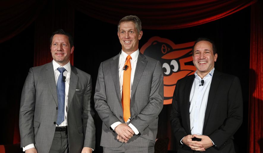 Mike Elias, center, the Baltimore Orioles&#x27; new executive vice president and general manager, poses for a photo with Orioles ownership representative Louis Angelos, left, and executive vice president John Angelos, right, after a baseball news conference Nov. 19, 2018, in Baltimore. Orioles CEO John Angelos was accused in a lawsuit this week of seizing control of the team at the expense of his brother Lou — and in defiance of their father Peter&#x27;s wishes. (AP Photo/Patrick Semansky, File) **FILE**