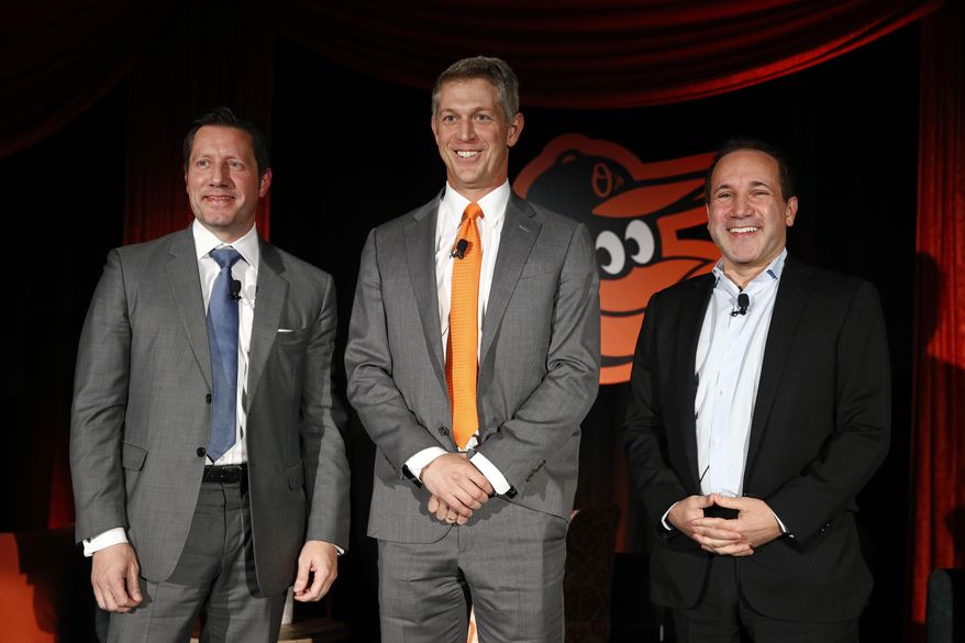 Mike Elias, center, the Baltimore Orioles&#x27; new executive vice president and general manager, poses for a photo with Orioles ownership representative Louis Angelos, left, and executive vice president John Angelos, right, after a baseball news conference Nov. 19, 2018, in Baltimore. Orioles CEO John Angelos was accused in a lawsuit this week of seizing control of the team at the expense of his brother Lou — and in defiance of their father Peter&#x27;s wishes. (AP Photo/Patrick Semansky, File) **FILE**