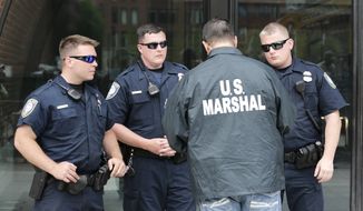 A U.S. Marshal instructs Dept. of Homeland Security officers outside the Moakley Federal Court in Boston, Friday, May 15, 2015. (AP Photo/Charles Krupa)