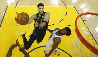 Boston Celtics forward Jayson Tatum, left, shoots against Golden State Warriors forward Andrew Wiggins during the second half of Game 5 of basketball&#39;s NBA Finals in San Francisco, Monday, June 13, 2022. (AP Photo/Jed Jacobsohn, Pool) **FILE**