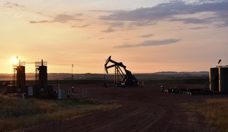 An oil well works at sunrise Aug. 25, 2021, in Watford City, N.D., part of McKenzie County. U.N. Secretary-Antonio Guterres warned Tuesday, June 14, of a “dangerous disconnect” between what scientists and citizens are demanding to curb climate change, and what governments are actually doing about it. Guterres said the war in Ukraine risked worsening the crisis, because major economies were “doubling down on fossil fuels” that are to blame for much of the emissions stoking global warming. (AP Photo/Matthew Brown, File)