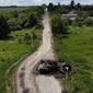 A ruined tank remains on a road in Lypivka, on the outskirts of Kyiv, Ukraine, Tuesday, June 14, 2022. Russia’s invasion of Ukraine is spreading a deadly litter of mines, bombs and other explosive devices that will endanger civilian lives and limbs long after the fighting stops. (AP Photo/Natacha Pisarenko)
