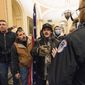 Kevin Seefried, second from left, holds a Confederate battle flag as he and other insurrectionists loyal to President Donald Trump are confronted by U.S. Capitol Police officers outside the Senate Chamber inside the Capitol in Washington, Jan. 6, 2021. A federal judge on Wednesday, June 15, 2022, convicted Kevin Seefried and his adult son Hunter Seefried of charges that they stormed the U.S. Capitol together to obstruct Congress from certifying President Joe Biden’s 2020 electoral victory. (AP Photo/Manuel Balce Ceneta, File)