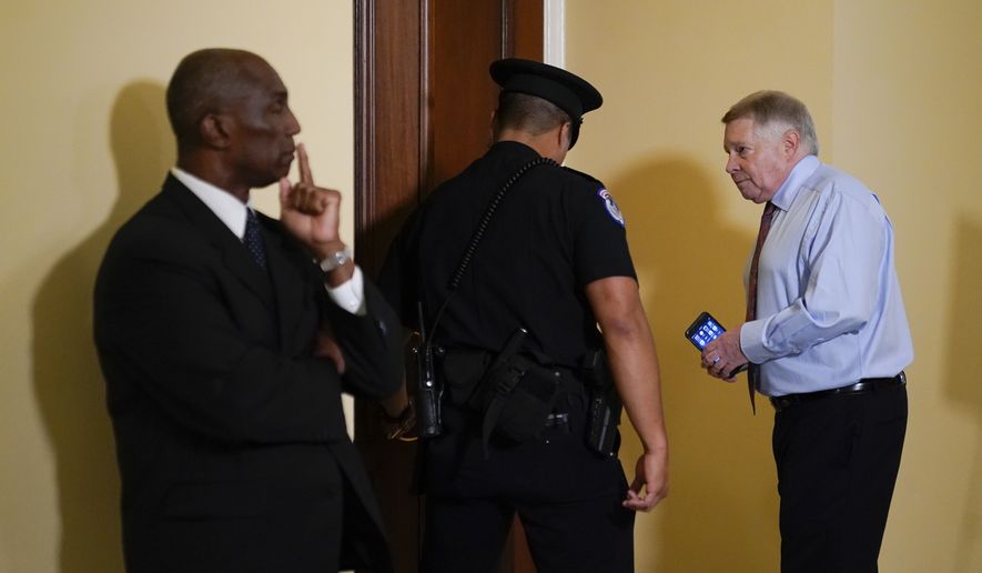 Retired U.S. Appeals Court Judge J. Michael Luttig, right, who was an informal adviser to Vice President Mike Pence, is escorted to a hearing room prior to testifying before a House select committee investigating the Jan. 6, 2021, attack on the Capitol in Washington, Thursday, June 16, 2022. (AP Photo/Patrick Semansky)