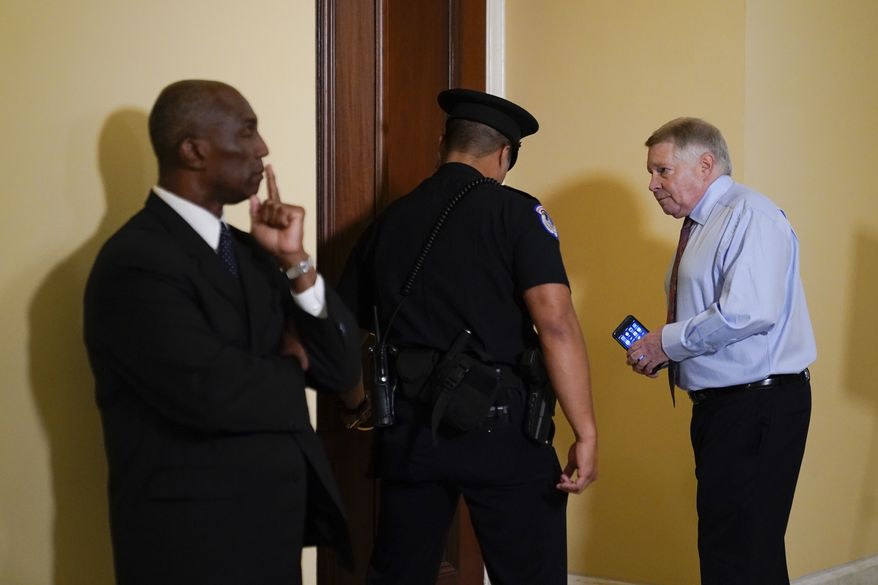 Retired U.S. Appeals Court Judge J. Michael Luttig, right, who was an informal adviser to Vice President Mike Pence, is escorted to a hearing room prior to testifying before a House select committee investigating the Jan. 6, 2021, attack on the Capitol in Washington, Thursday, June 16, 2022. (AP Photo/Patrick Semansky)
