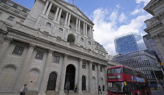 FILE - A bus drives past the Bank of England before the release of the Monetary Policy Report at the Bank of England in London, Thursday, May 5, 2022. The Bank of England is under pressure to raise interest rates more aggressively amid concern that the quarter-percentage-point hike expected Thursday will do little to combat price increases that have pushed inflation to a 40-year high. (AP Photo/Frank Augstein, File)