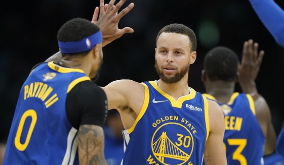 Golden State Warriors guard Stephen Curry (30) high fives Golden State Warriors guard Gary Payton II (0) during the second quarter of Game 6 of basketball&#39;s NBA Finals against the Boston Celtics, Thursday, June 16, 2022, in Boston. (AP Photo/Steven Senne)