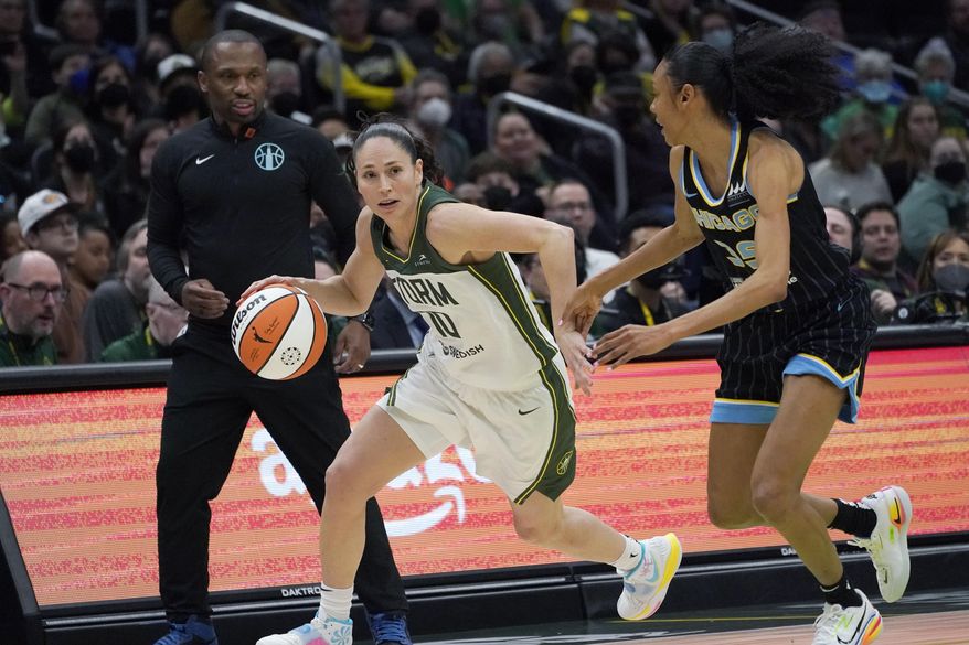 Seattle Storm guard Sue Bird (10) drives around Chicago Sky guard Rebekah Gardner, right, as Sky coach James Wade, left, watches during the second half of a WNBA basketball game Wednesday, May 18, 2022 in Seattle. The Storm won 74-71. (AP Photo/Ted S. Warren)
