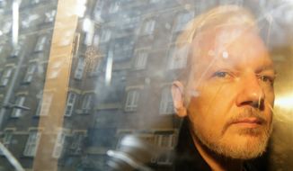 FILE - Buildings are reflected in the window as WikiLeaks founder Julian Assange is taken from court, where he appeared on charges of jumping British bail seven years ago, in London, Wednesday May 1, 2019. The British government on Friday, June 17, 2022 ordered the extradition of WikiLeaks founder Julian Assange to the United States to face spying charges. He is likely to appeal. (AP Photo/Matt Dunham, File)