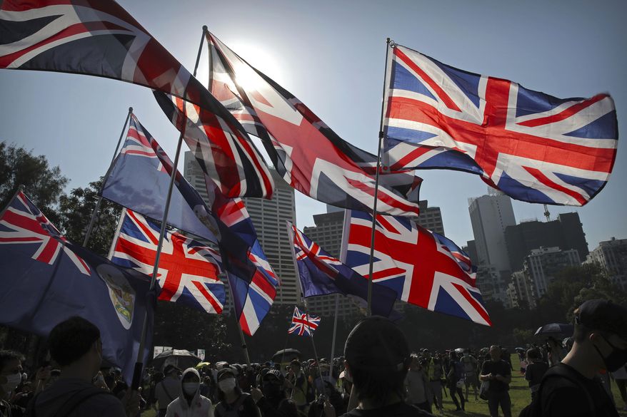Demonstrators wave British flags during an anti-government protest in Hong Kong, Saturday, Nov. 2, 2019. Hong Kong is preparing to introduce new middle school textbooks that will deny the Chinese territory was ever a British colony. (AP Photo/Kin Cheung, File)