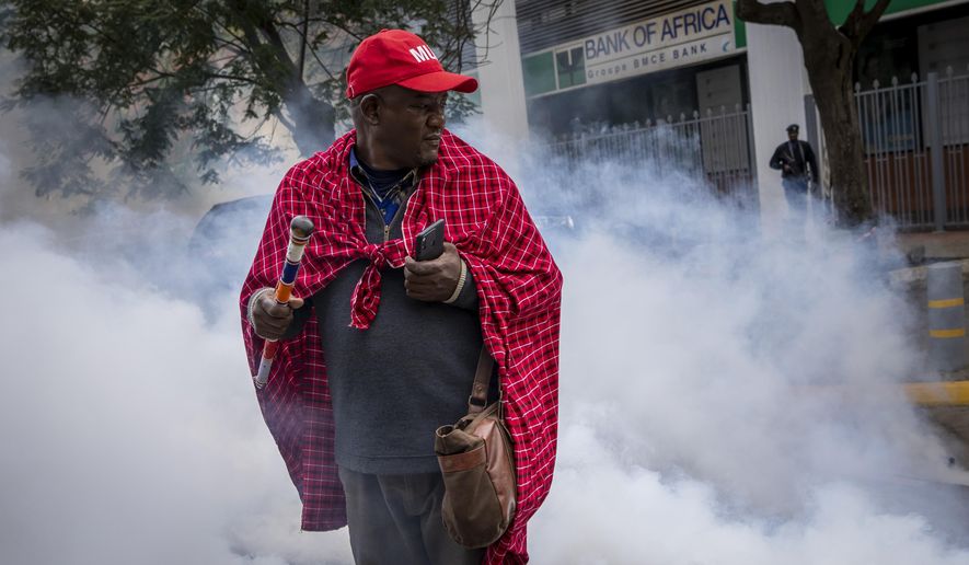 Jonathan Mpute ole Pasha, national coordinator of the Maa Unity Agenda group, is surrounded by tear gas thrown by police to break up a small demonstration of Maasai rights activists outside the Tanzanian high commission in downtown Nairobi, Kenya Friday, June 17, 2022. Tanzania&#39;s government is accused of violently trying to evict Maasai herders from one of the country&#39;s most popular tourist destinations, the Ngorongoro Conservation Area. (AP Photo/Ben Curtis)
