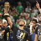 Golden State Warriors guard Stephen Curry, center, holds up the Bill Russell Trophy for most valuable player after the Warriors defeated the Boston Celtics in Game 6 to win basketball&#39;s NBA Finals championship, Thursday, June 16, 2022, in Boston. (AP Photo/Steven Senne) **FILE**