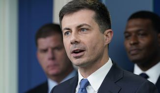 Transportation Secretary Pete Buttigieg (center) speaks during a briefing at the White House in Washington, May 16, 2022, as Labor Secretary Marty Walsh (left) and Environmental Protection Agency administrator Michael Regan listen. Buttigieg says he is pushing airlines to hire more customer-service people and take other steps to help travelers this summer. (AP Photo/Susan Walsh) ** FILE **
