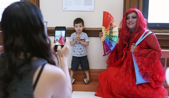 A drag queen who goes by the name Flame poses for a picture with Thomas Delattre, 2, during a Drag Story Hour at a public library in New York, Friday, June 17, 2022. (AP Photo/Seth Wenig)  **FILE**
