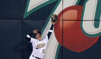 Oakland Athletics left fielder Chad Pinder makes a leaping catch at the wall on a ball hit by Kansas City Royals&#39; Bobby Witt Jr. during the sixth inning of a baseball game Friday, June 17, 2022, in Oakland, Calif. (AP Photo/D. Ross Cameron)