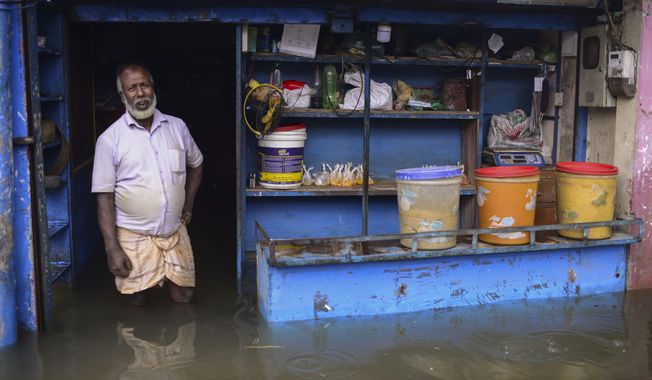 A man stands at the doorway of his flooded shop in Sylhet, Bangladesh, Monday, June 20, 2022. Floods in Bangladesh continued to wreak havoc Monday with authorities struggling to ferry drinking water and  dry food to flood shelters across the country’s vast northern and northeastern regions. (AP Photo/Mahmud Hossain Opu)