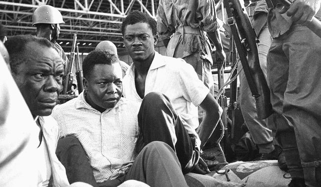Congo&#x27;s former prime minister Patrice Lumumba, center right, with hands tied behind his back, sits in a truck upon arrival at Leopoldville (now Kinshasa) Airport in Congo, Dec. 2, 1960, following his arrest the previous day. On Monday, more than sixty one years after his death, the mortal remains of Congo&#x27;s first democratically elected prime minister Patrice Lumumba will be handed over to his children during an official ceremony in Belgium. (AP Photo, File)