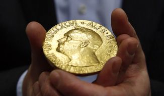 Bidder Ole Bjorn Fausa, of Norway, holds the 1936 Nobel Peace Prize medal in Baltimore, March 27, 2014, the second Nobel Peace Prize ever to come to auction. The Nobel Peace Prize, won last October by Russian journalist Dmitri A. Muratov, will be offered at auction, Monday, June 20, 2022, with proceeds going to help children displaced by the war in Ukraine. (AP Photo/Patrick Semansky, File)