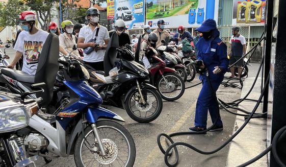 People wait for gas pump in Hanoi, Vietnam Sunday, June 19, 2022. Across the globe, drivers are rethinking their habits and personal finances amid skyrocketing prices for gasoline and diesel, fueled by Russia&#x27;s war in Ukraine and the global rebound from the COVID-19 pandemic. Energy prices are a key driver of inflation that is rising worldwide and making the cost of living more expensive.(AP Photo/Hau Dinh)