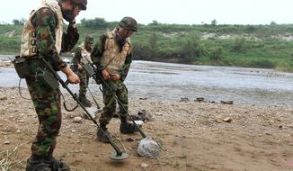 In this Aug. 1, 2010 file photo, South Korean Army soldiers search for landmines near the demilitarized zone that separates the two Koreas in Yeoncheon, north of Seoul, South Korea. The White House announced Tuesday a new policy curtailing the use of anti-personnel land mines by the U.S. military, reversing a more permissive stance that was enacted by former President Donald Trump. Under the policy, such explosives will still be allowed to defend South Korea against a potential attack by North Korea, but otherwise they will be banned. (Lim Byung-shick/Yonhap via AP, File)