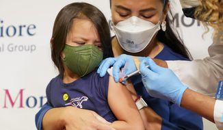 Maria Assisi holds her daughter Mia, 4 as Registered Nurse Margie Rodriguez administers the first dose of the Moderna COVID-19 vaccine for children 6 months through 5 years old, Tuesday, June 21, 2022, at Montefiore Medical Group in the Bronx borough of New York. (AP Photo/Mary Altaffer)