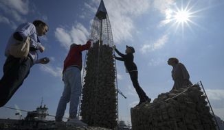 People build a model of the business tower Lakhta Centre, at the headquarters of Russian gas monopoly Gazprom, filling the frame with stones, in St. Petersburg, Russia, Thursday, June 9, 2022. It&#39;s not a summer heat wave that&#39;s making European leaders and businesses sweat. It&#39;s fear that Russia&#39;s manipulation of natural gas supplies will lead to an economic and political crisis next winter. Or, in the worst case, even sooner. (AP Photo/Dmitri Lovetsky, File)