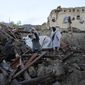 Afghans stand among destruction after an earthquake in Gayan village, in Paktika province, Afghanistan, Thursday, June 23, 2022. A powerful earthquake struck a rugged, mountainous region of eastern Afghanistan early Wednesday, flattening stone and mud-brick homes in the country&#39;s deadliest quake in two decades, the state-run news agency reported. (AP Photo/Ebrahim Nooroozi)