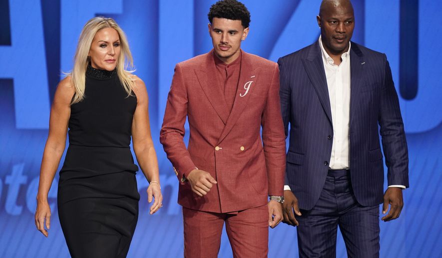 Johnny Davis, center, walks on stage during introductions for the NBA basketball draft, Thursday, June 23, 2022, in New York. (AP Photo/John Minchillo)