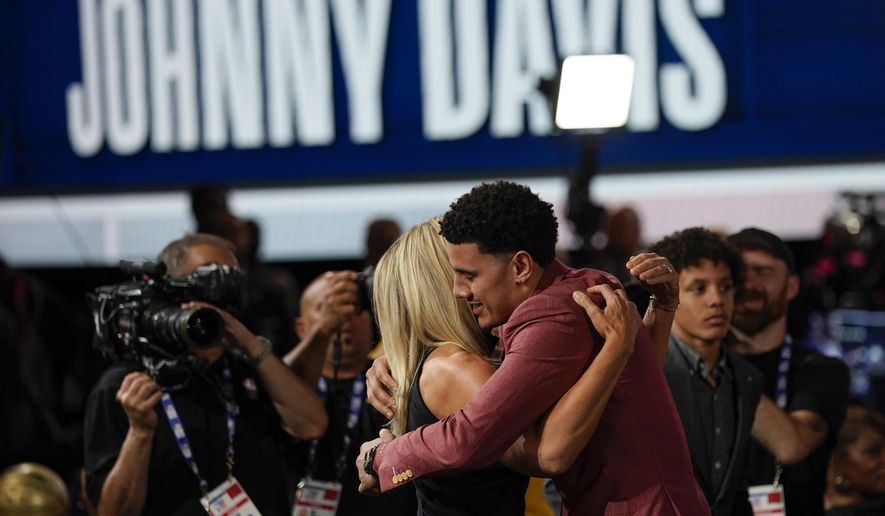 Johnny Davis hugs family and friends after being selected 10th overall by the Washington Wizards in the NBA basketball draft, Thursday, June 23, 2022, in New York. (AP Photo/John Minchillo)