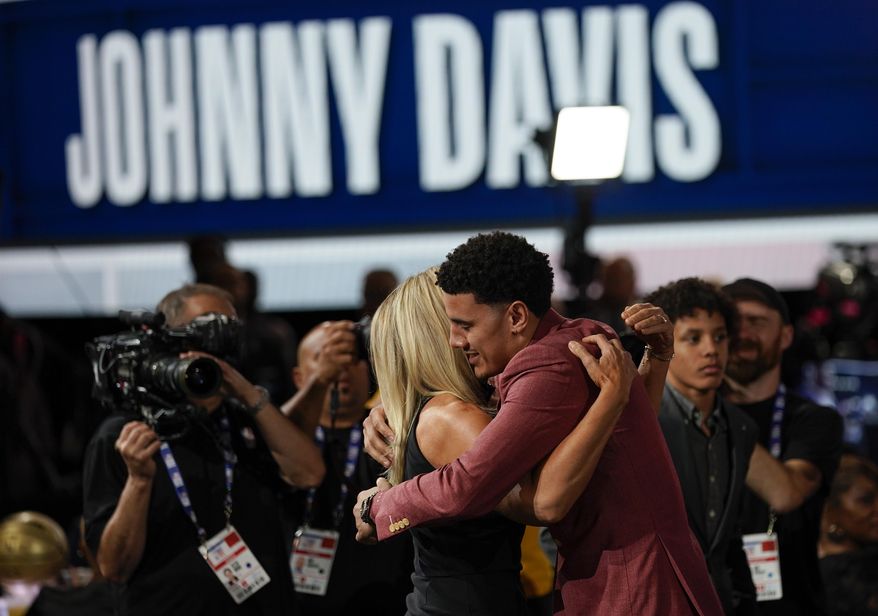 Johnny Davis hugs family and friends after being selected 10th overall by the Washington Wizards in the NBA basketball draft, Thursday, June 23, 2022, in New York. (AP Photo/John Minchillo)