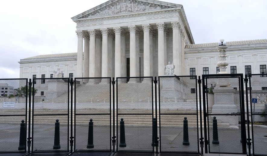 Anti-scaling fencing is seen outside the Supreme Court, Thursday, June 23, 2022, in Washington. On the eve of a ruling on abortion rights, a new Gallup poll shows a historic low in public confidence in the nation's high court. (AP Photo/Jacquelyn Martin) **FILE**