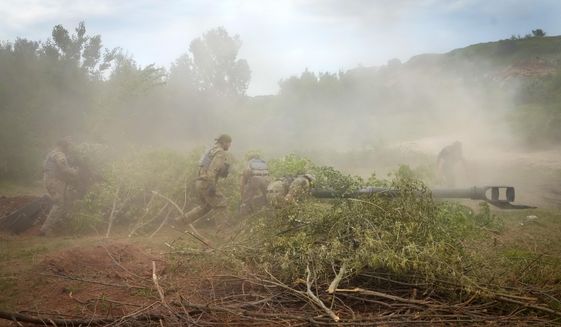 Ukrainian soldiers camouflage a U.S.-supplied M777 howitzer with tree branches after they fired at Russian position in Ukraine&#39;s eastern Donetsk region Saturday, June 18, 2022. (AP Photo/Efrem Lukatsky)