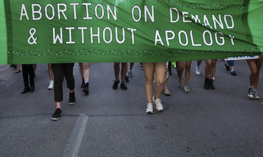 Abortion-rights protesters march down Congress Avenue in downtown Austin, Texas following the Supreme Court decision to overturn Roe v. Wade, June 24, 2022. Friday, June 24, 2022. (Sara Diggins/Austin American-Statesman via AP)