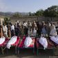 Afghans stand by the bodies of relatives killed in an earthquake in Gayan village, in Paktika province, Afghanistan, Thursday, June 23, 2022. A powerful earthquake struck a rugged, mountainous region of eastern Afghanistan early Wednesday, flattening stone and mud-brick homes in the country&#39;s deadliest quake in two decades, the state-run news agency reported. (AP Photo/Ebrahim Nooroozi)