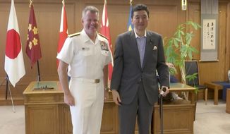 In this image made from a video, U.S. Pacific Fleet commander Adm. Sam Paparo, left, and Japanese Defense Minister Nobuo Kishi pose for media at the Defense Ministry in Tokyo, Friday, June 24, 2022. The U.S. Navy’s top commander in the Pacific and the Japanese defense minister on Friday said close cooperation between their naval forces is more important than ever amid rising tensions over China, North Korea and Russia. (AP Photo)