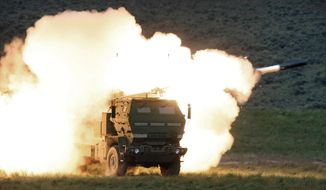 In this May 23, 2011, photo, a launch truck fires the High Mobility Artillery Rocket System (HIMARS) produced by Lockheed Martin during combat training in the high desert of the Yakima Training Center, Wash. U.S. officials will send another $450 million in military aid to Ukraine, including some additional medium-range rocket systems. The latest package will include a number of High Mobility Artillery Rocket Systems, or HIMARS. (Tony Overman/The Olympian via AP) **FILE**
