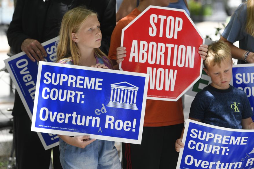 Grace Miller 11, left, and Leo Miller 5, right, hold signs during a Pro-Life rally at Federal Plaza Friday, June 24, 2022, in Chicago, after the Supreme Court overturned Roe v. Wade. (AP Photo/Paul Beaty)