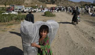 Afghan girl carries a donated matrace after an earthquake in Gayan village, in Paktika province, Afghanistan, Friday, June 24, 2022. A powerful earthquake struck a rugged, mountainous region of eastern Afghanistan early Wednesday, flattening stone and mud-brick homes in the country&#39;s deadliest quake in two decades, the state-run news agency reported. (AP Photo/Ebrahim Nooroozi