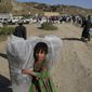Afghan girl carries a donated matrace after an earthquake in Gayan village, in Paktika province, Afghanistan, Friday, June 24, 2022. A powerful earthquake struck a rugged, mountainous region of eastern Afghanistan early Wednesday, flattening stone and mud-brick homes in the country&#39;s deadliest quake in two decades, the state-run news agency reported. (AP Photo/Ebrahim Nooroozi