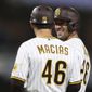 San Diego Padres&#x27; Austin Nola smiles next to first base coach David Macias after hitting an RBI single against the Philadelphia Phillies during the sixth inning of a baseball game Friday, June 24, 2022, in San Diego. (AP Photo/Derrick Tuskan)