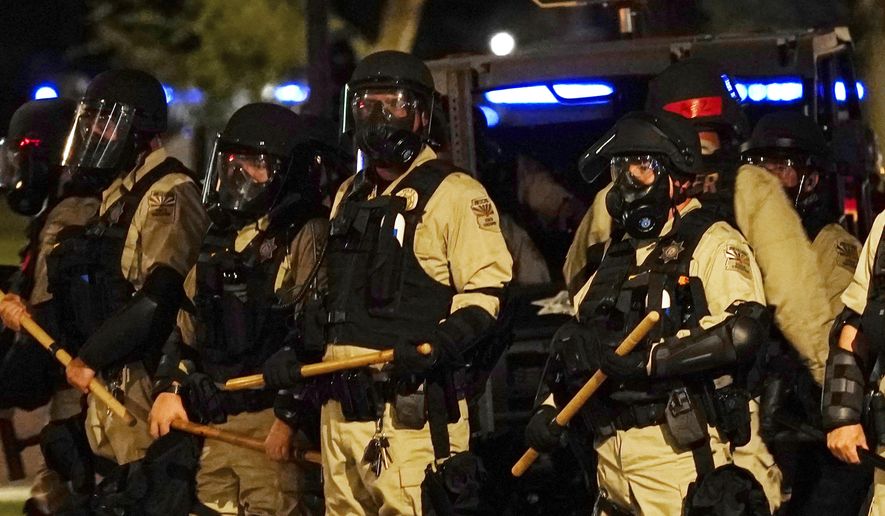Police in riot gear surround the Arizona Capitol after protesters reached the front of the Arizona Sentate building as protesters reacted to the Supreme Court decision to overturn the landmark Roe v. Wade abortion decision Friday, June 24, 2022, in Phoenix. (AP Photo/Ross D. Franklin)