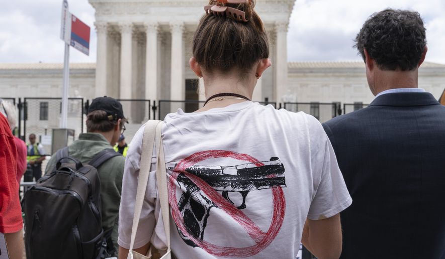 A woman wears an anti-gun T-shirt outside of the Supreme Court, following the Supreme Court&#39;s decision to overturn Roe v. Wade in Washington, Friday, June 24, 2022. The Supreme Court on Thursday struck down a New York state law that had restricted who could obtain a permit to carry a gun in public.(AP Photo/Jacquelyn Martin)