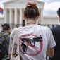 A woman wears an anti-gun T-shirt outside of the Supreme Court, following the Supreme Court&#39;s decision to overturn Roe v. Wade in Washington, Friday, June 24, 2022. The Supreme Court on Thursday struck down a New York state law that had restricted who could obtain a permit to carry a gun in public.(AP Photo/Jacquelyn Martin)