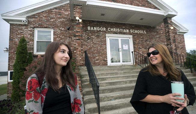 Bangor Christian Schools sophomore Olivia Carson, 15, of Glenburn, Maine, left, stands with her mother Amy while getting dropped off on the first day of school on August 28, 2018 in Bangor, Maine. The Carsons were one of three Maine families that challenged the prohibition on using public money to pay tuition at religious schools. The Supreme Court ruled that Maine can&#x27;t exclude religious schools from a program that offers tuition aid for private education in towns that don&#x27;t have public schools. (Gabor Degre/The Bangor Daily News via AP, File)