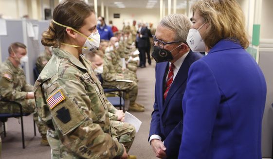 Ohio Gov. Mike DeWine, center, and his wife Fran, right, talk with specialist Emily Milosevic as they tour the Defense Supply Center Columbus in Columbus, Ohio, as members of the Ohio Army National Guard prepare to deploy to aid Ohio hospitals during the current surge in COVID-19 hospitalizations Jan. 6, 2022. Up to 40,000 Army National Guard soldiers across the country - or about 13% of the force — have not yet gotten the mandated COVID-19 vaccine, and as the deadline for shots looms, at least 14,000 of them have flatly refused and could be forced out of the service. (AP Photo/Paul Vernon, File)