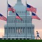 In this Sept. 27, 2017, file photo, an early morning runner crosses in front of the U.S. Capitol as he passes the flags circling the Washington Monument in Washington. (AP Photo/J. David Ake, File)