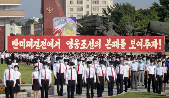 People gather for at a mass rally to mark what North Korea calls &quot;the day of struggle against U.S. imperialism&quot;,  the anniversary of the start of the Korean War,  at the plaza of the Victorious Fatherland Liberation War Museum in Pyongyang, on Saturday, June 25, 2022. The slogan says &quot;Let us show the mettle of heroic Korea in the anti-U.S. confrontation!&quot; (AP Photo/Cha Song Ho)