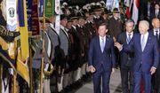 U.S. President Joe Biden, right, waves as he walks past Bavarian mountain riflemen and traditional costumers after his arrival at Franz-Josef-Strauss Airport near Munich, Germany, Saturday, June 25, 2022, ahead of the G7 summit. Biden is in Germany to attend a Group of Seven summit of leaders of the world&#39;s major industrialized nations. (Daniel Karmann/dpa via AP)